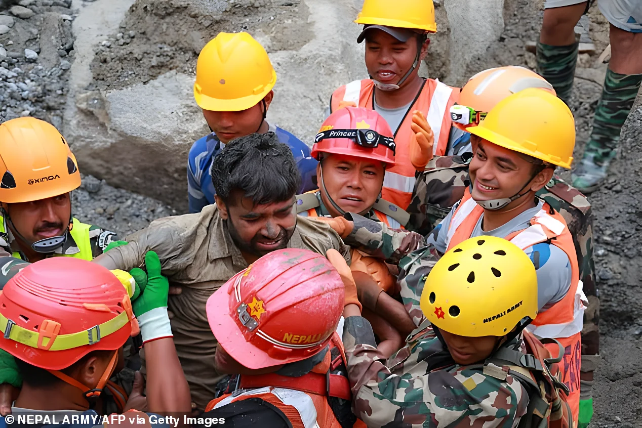 Dramatic photos showed about a dozen rescuers pulling a man from a small hole in the ground