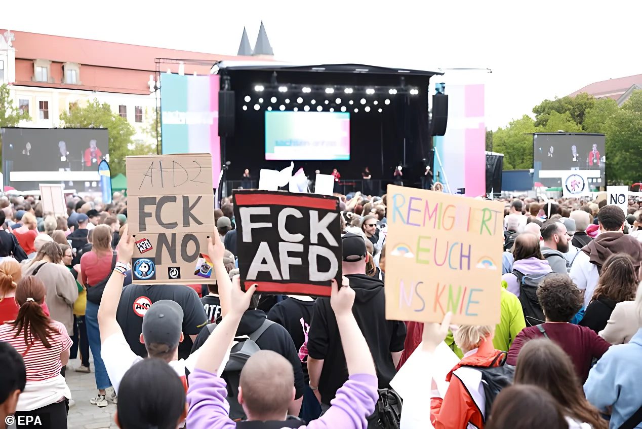 Participants hold placards in front of the Magdeburg Cathedral during a rally on September 5